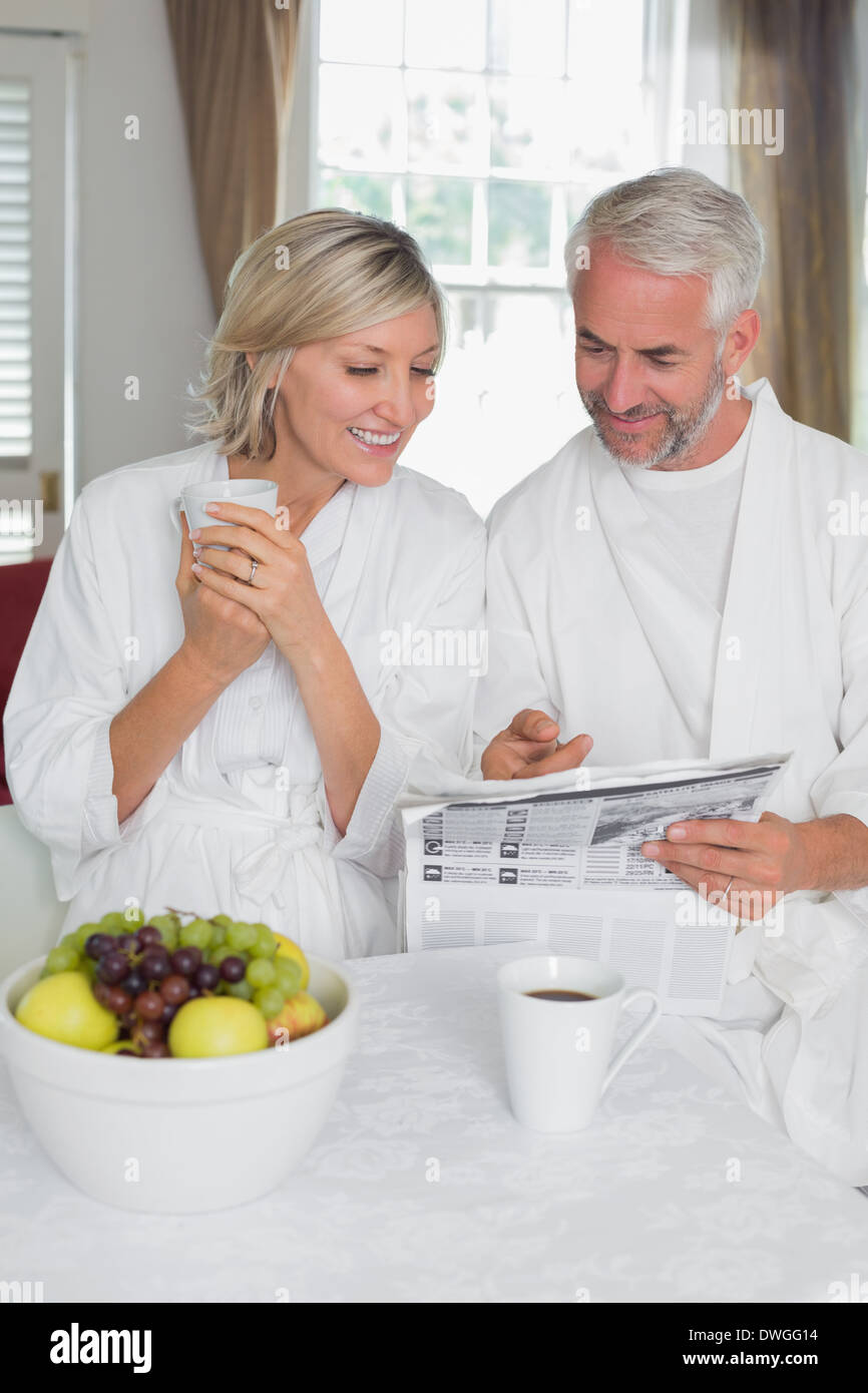 Couple reading newspaper while having breakfast Stock Photo