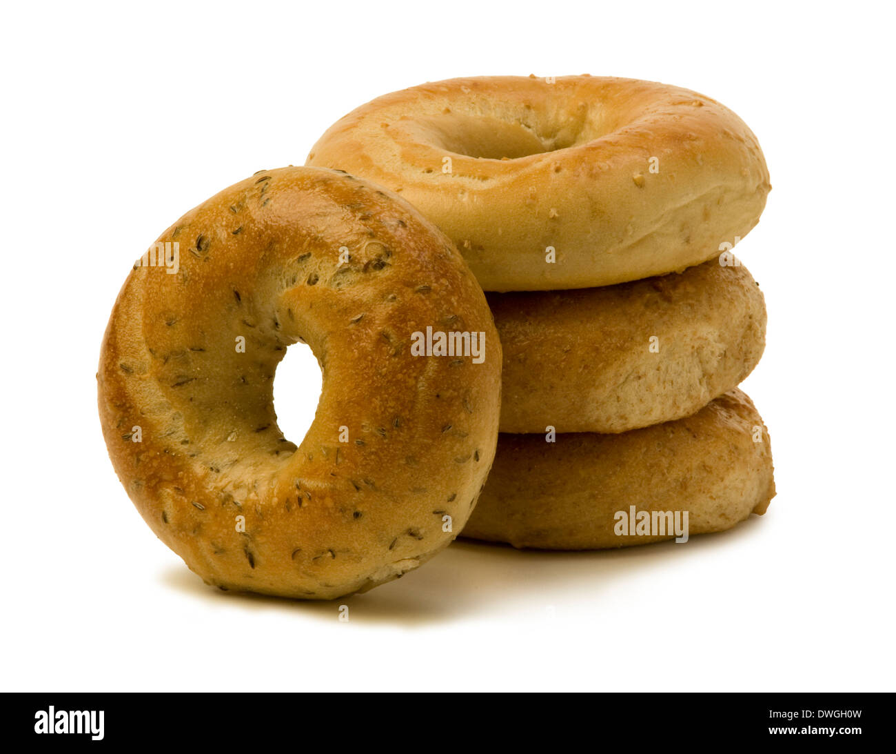 Stack of three bagels with one leaning on the side against white background. Stock Photo