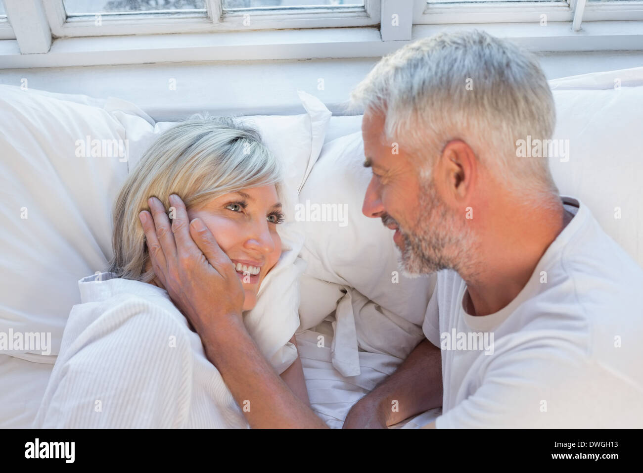 Close-up of a happy mature couple lying in bed Stock Photo - Alamy