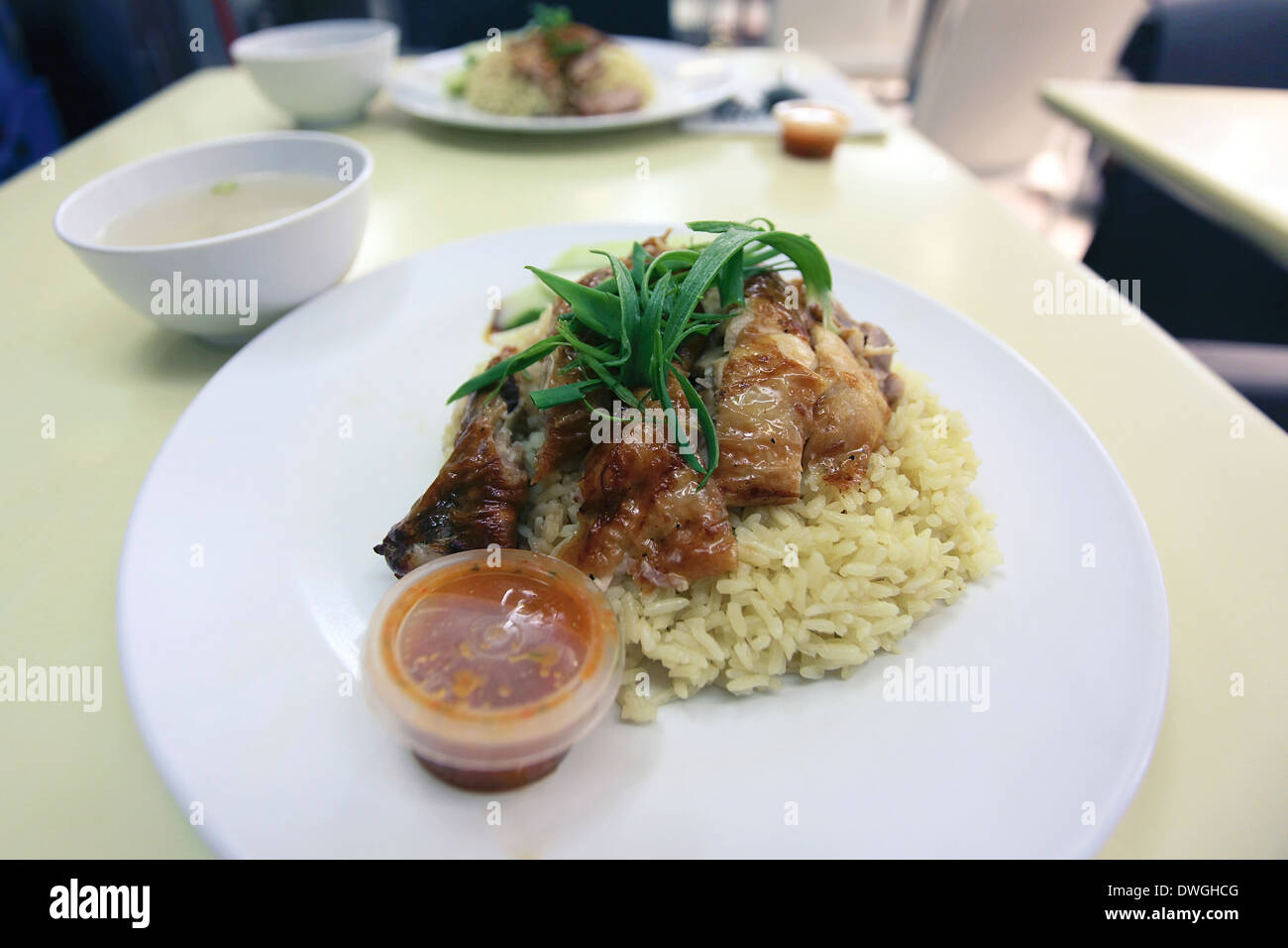 Malaysian Chicken Rice with Chicken Drumstick Over Fragrant Rice and Chili Sauce Closeup Stock Photo