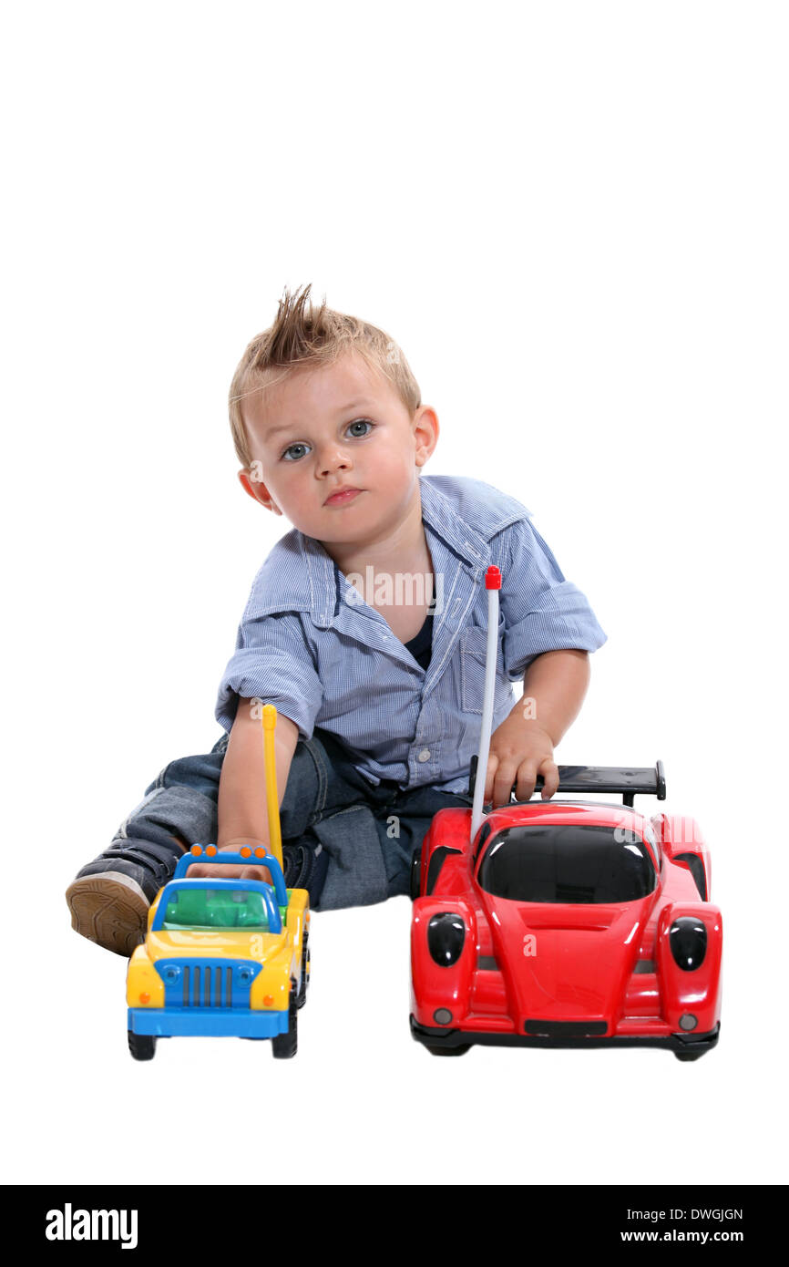 Tot with gelled hair playing with toy cars Stock Photo