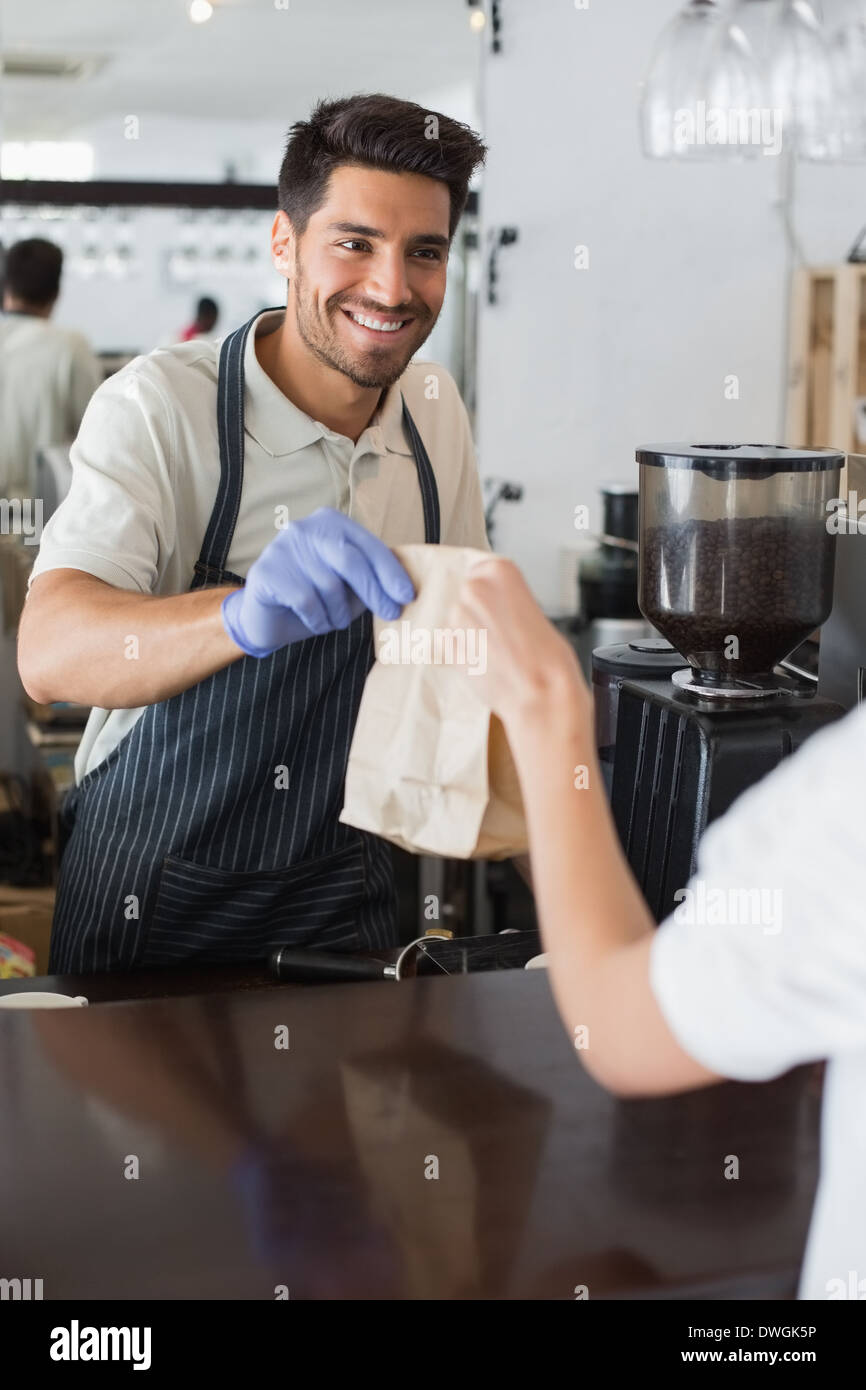 Waiter giving packed food to a woman at coffee shop Stock Photo