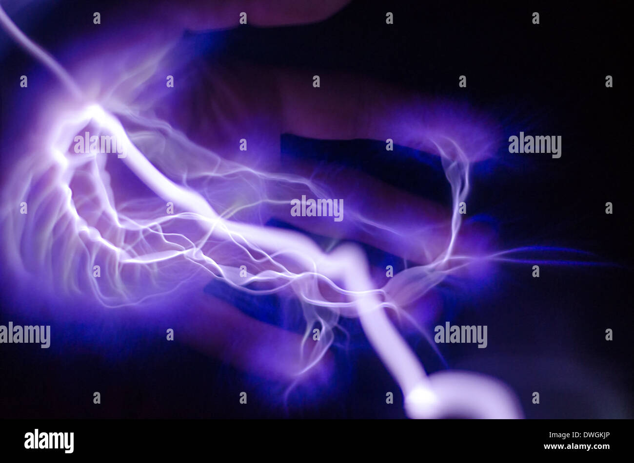 A hand with purple and blue lightning coming out of it Stock Photo
