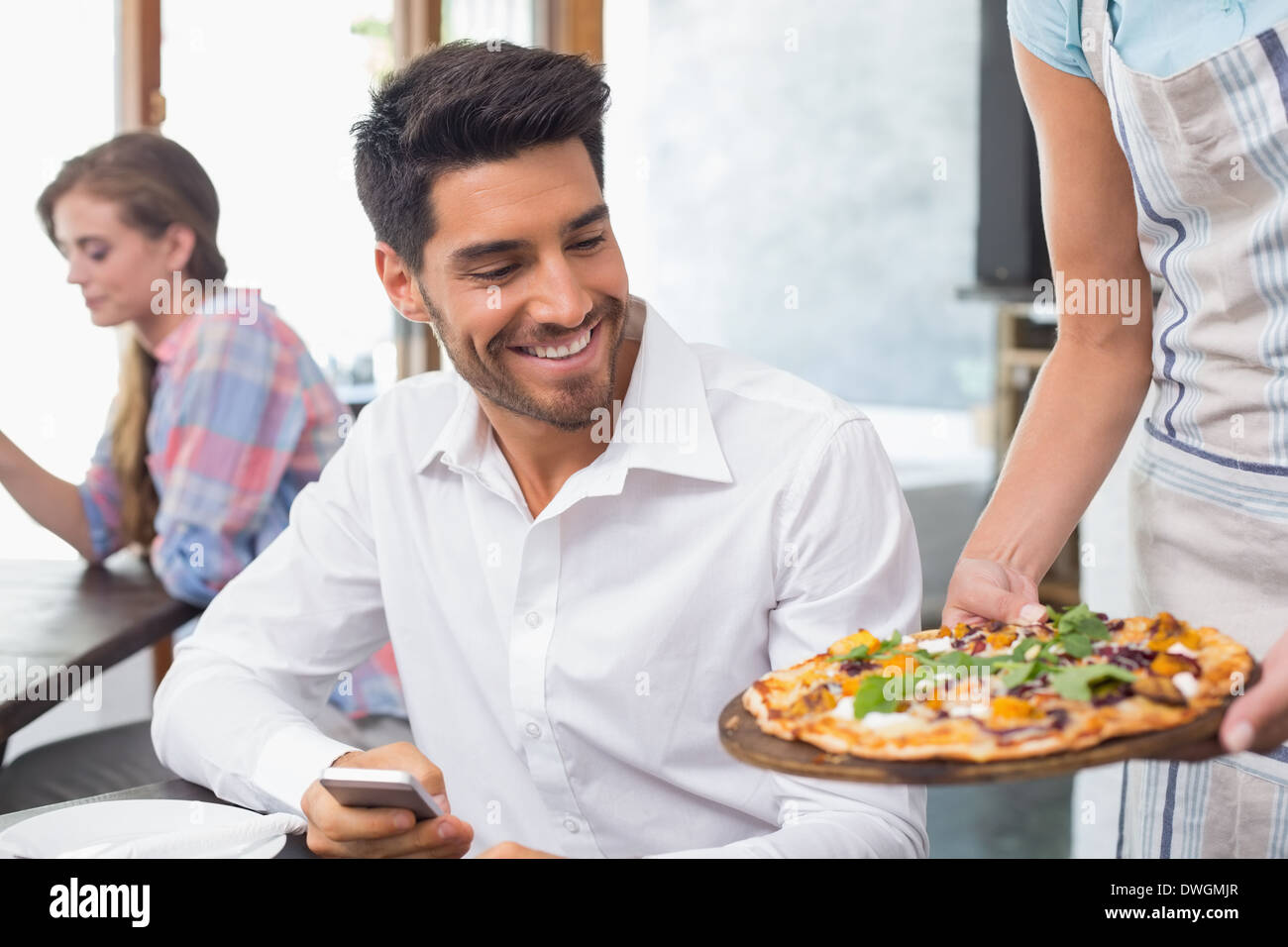 Waitress giving pizza to a man at coffee shop Stock Photo