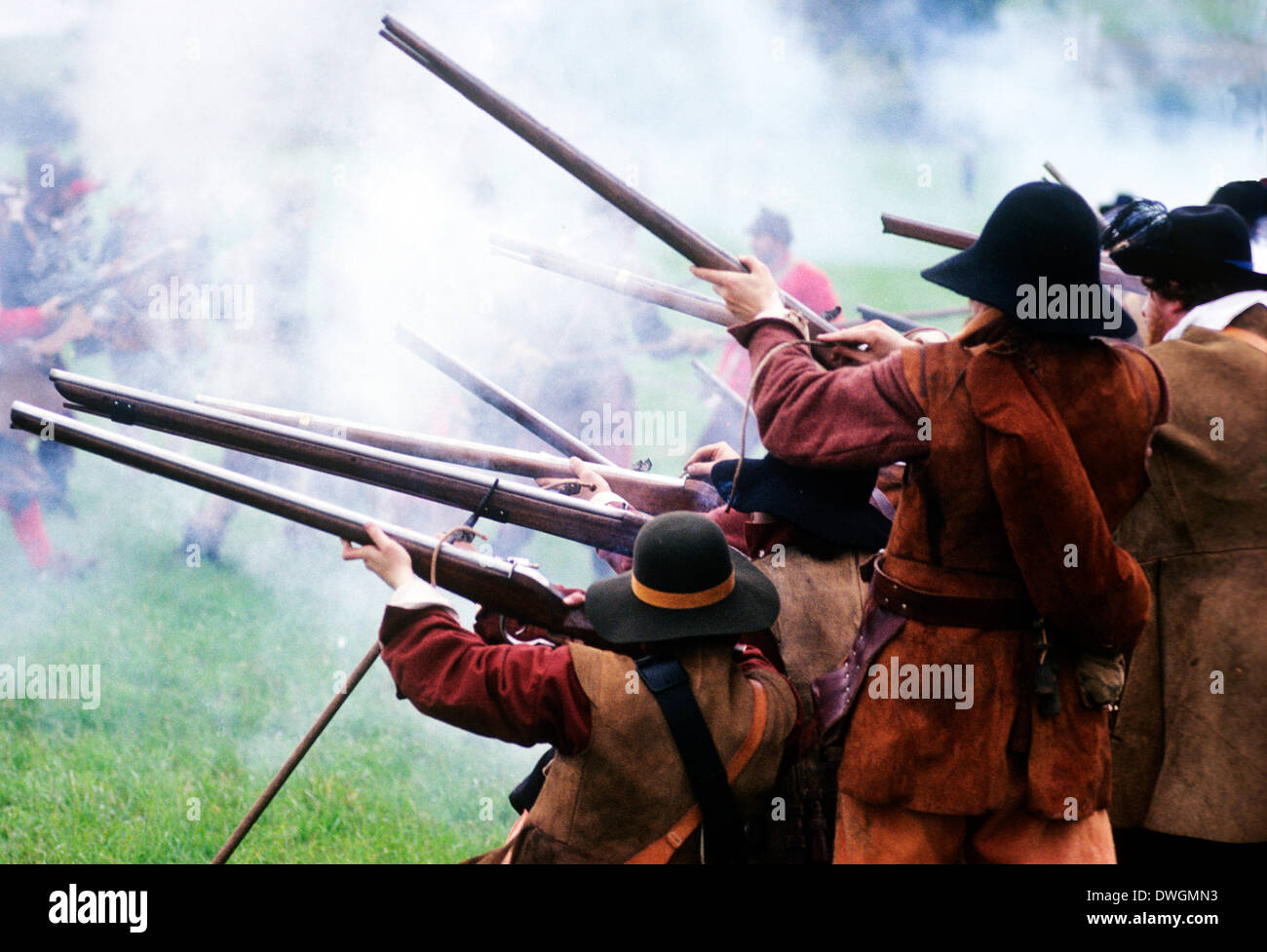 English Civil War, musket fire in battle, 17th century, historical re-enactment of Battle of Naseby soldier soldiers firing muskets gun smoke military uniform uniforms England UK Stock Photo