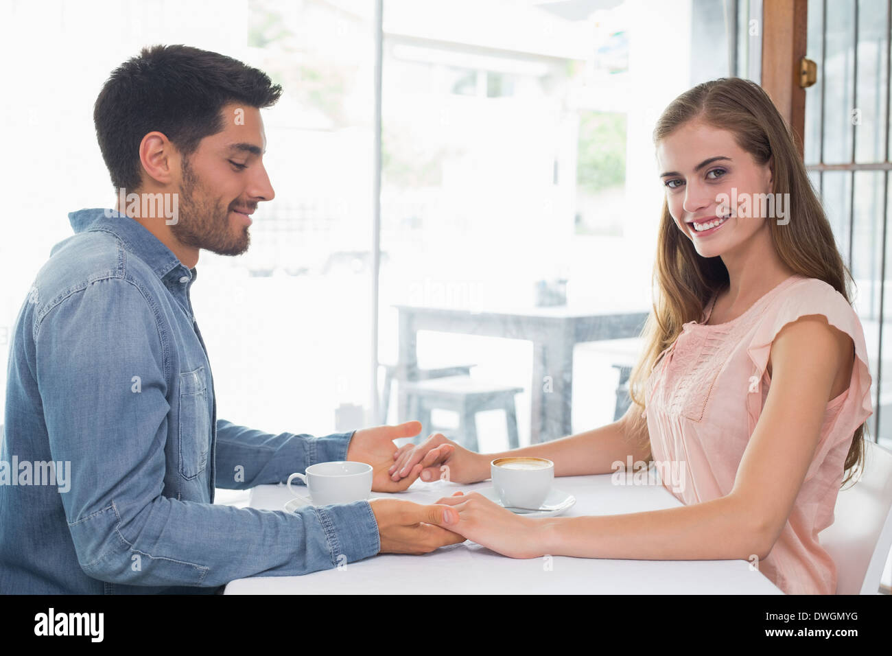 Romantic couple holding hands at coffee shop Stock Photo Alamy