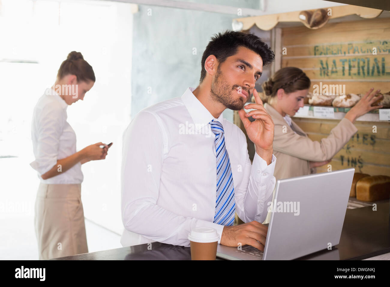 Businessman using laptop in office cafeteria Stock Photo
