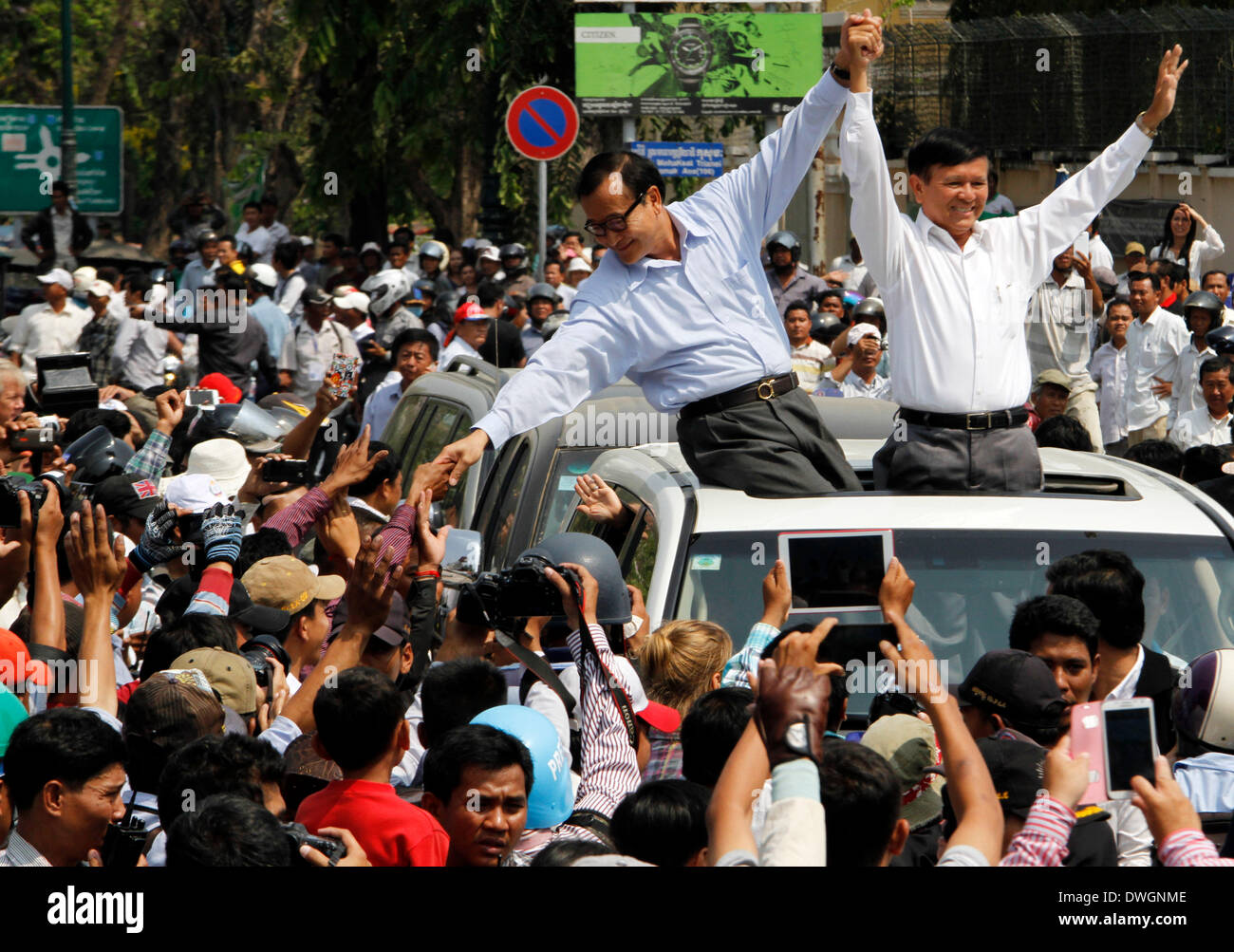 Phnom Penh, Cambodia. 8th Mar, 2014. Sam Rainsy (L, upper), leader of the opposition Cambodia National Rescue Party, and his deputy Kem Sokha (R, upper) appear at a rally near the Freedom Park in Phnom Penh, Cambodia, March 8, 2014. Hundreds of opposition-aligned trade union activists and workers illegally rallied on a street near the capital's Freedom Park on Saturday morning, calling for higher wages and release of 21 detained protesters. Credit:  Sovannara/Xinhua/Alamy Live News Stock Photo