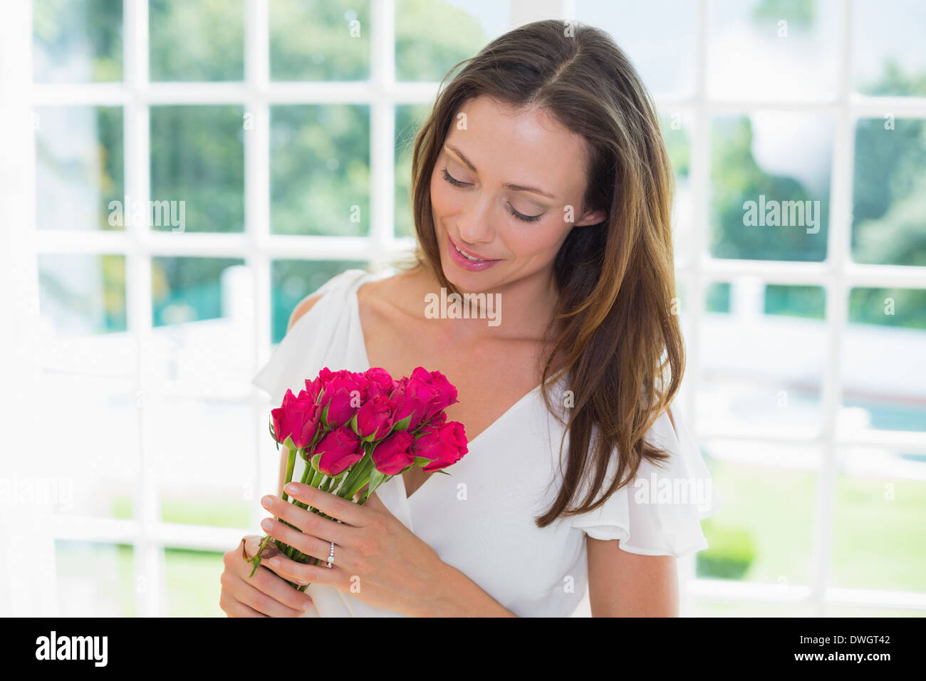 Thoughtful woman with flowers at home Stock Photo