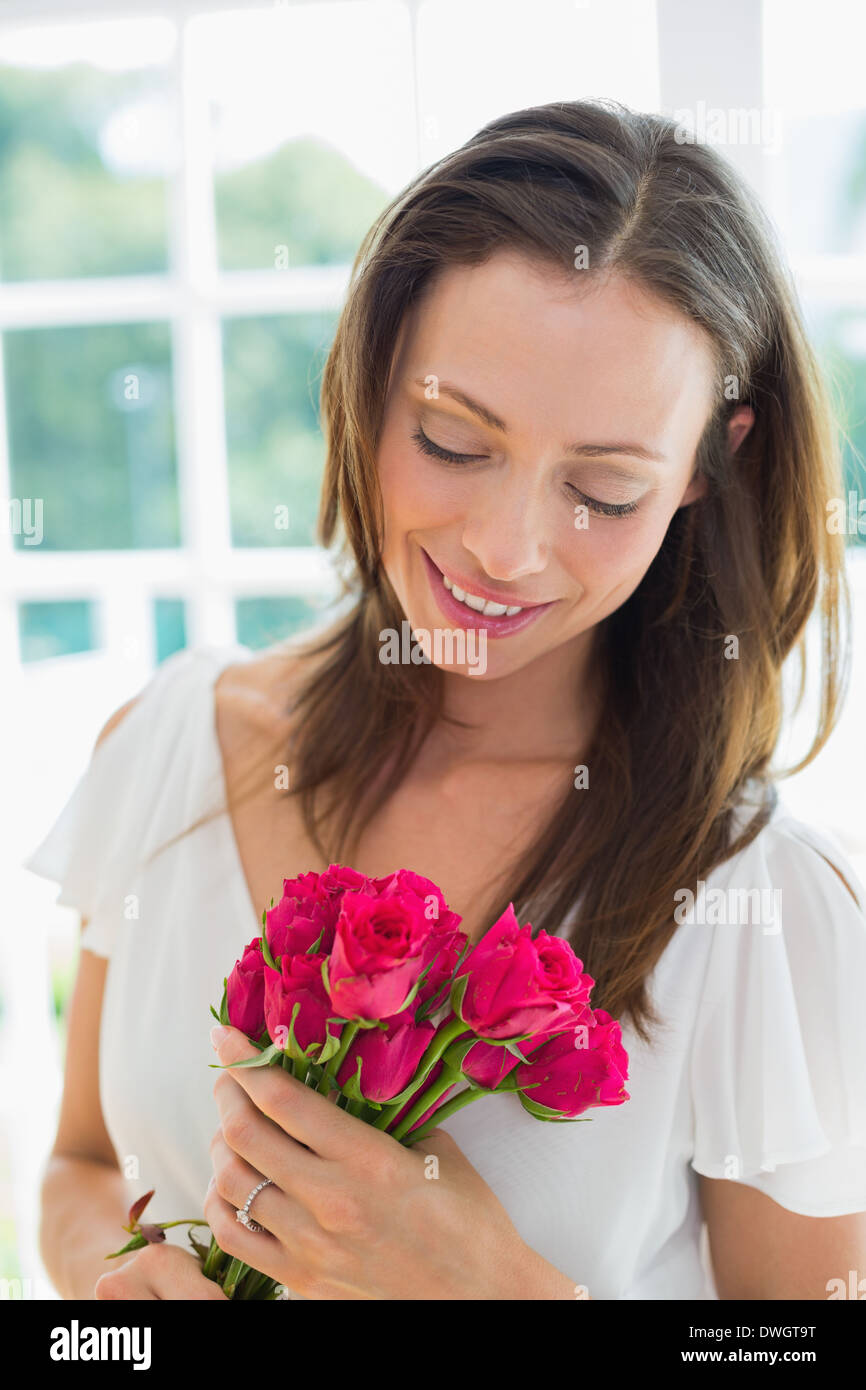 Thoughtful woman with flowers at home Stock Photo