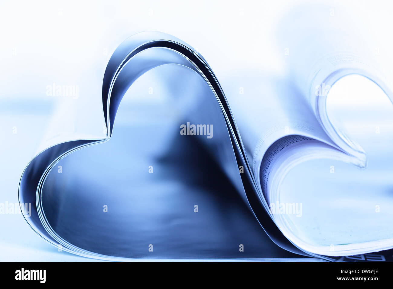 Two magazines folded to heart shape on table Stock Photo