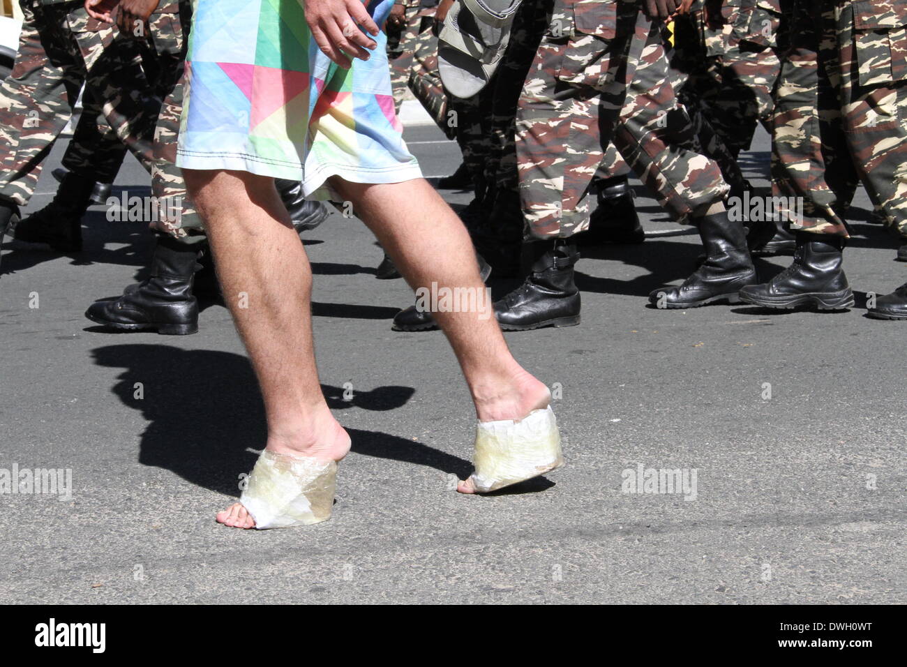 Windhoek, Namibia. 8th March 2014. A man wearing self-made high-heels walks with Namibian military band in a march to protest gender based violence in Windhoek. Dozens of men wearing high-heels participated in the 'Men March to Stop Gender Based Violence & Passion Killing in Namibia' in Namibian capital Windhoek on Saturday. The march aims to protest the surge of fatal crimes and violence against Namibian women since the beginning of this year, during which period over ten women were killed by their male partners in the southwestern African country Credit:  Xinhua/Alamy Live News Stock Photo