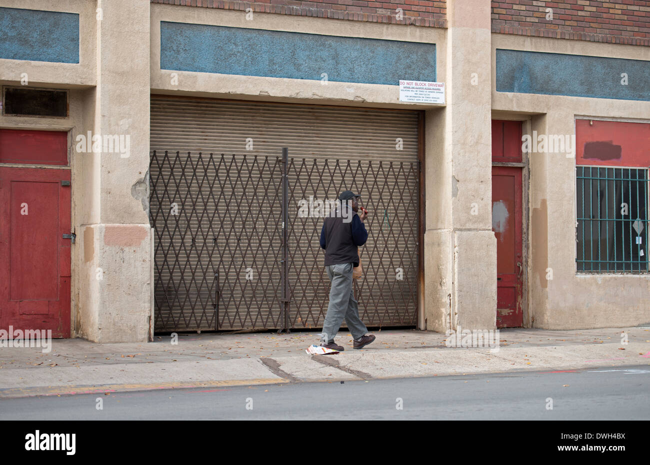 Man walking past old industrial building, East Village, San Diego, California Stock Photo