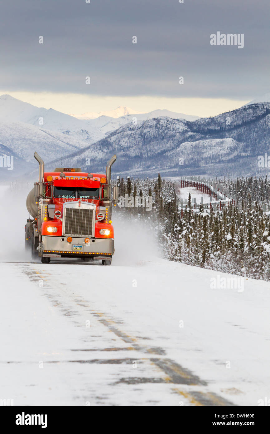 Red truck driving along the Dalton Highway ice road, Alaska in