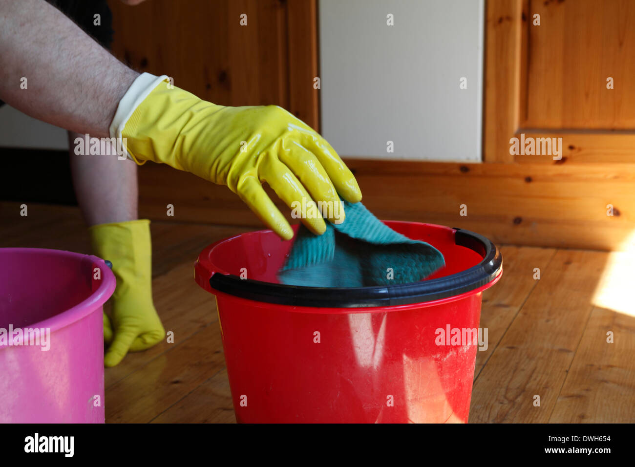 A man is scrubbing a wooden floor. Stock Photo