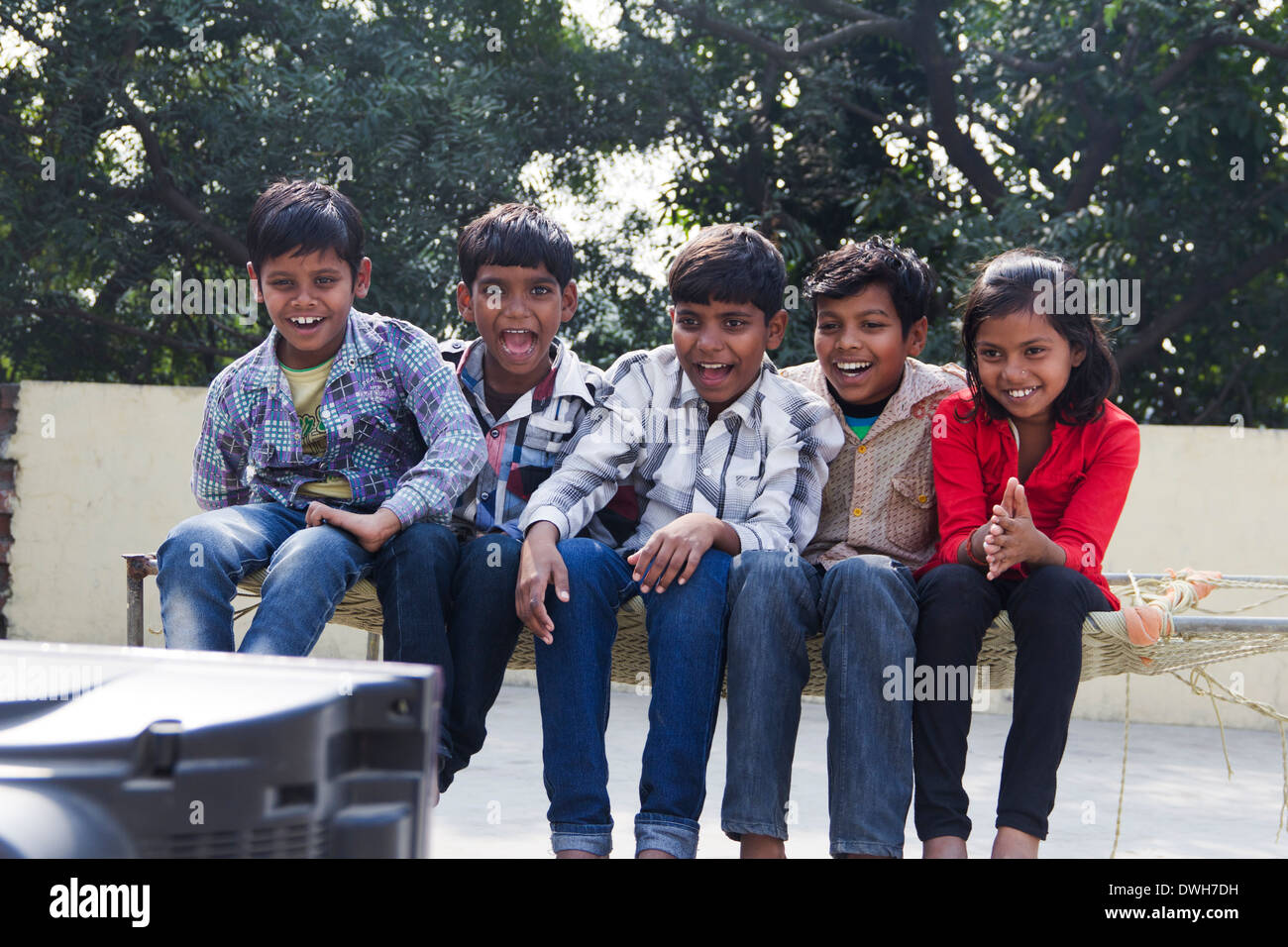 Indian Kids Sitting  and Watching Television Stock Photo