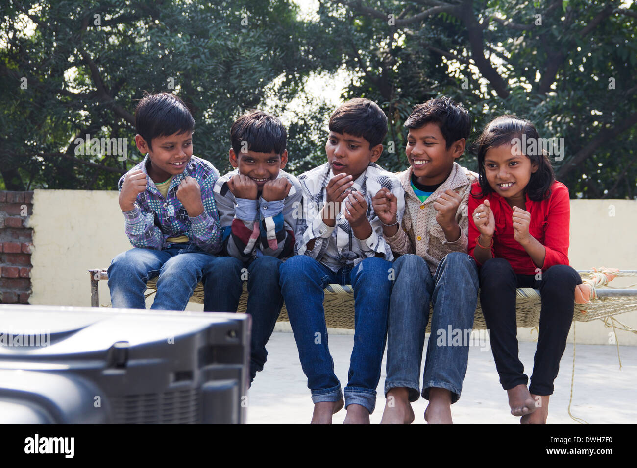 Indian Kids Sitting  and Watching Television Stock Photo