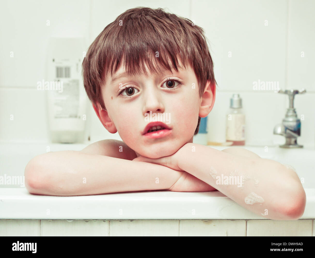 A six year old boy in the bath with a sad expression Stock Photo Alamy