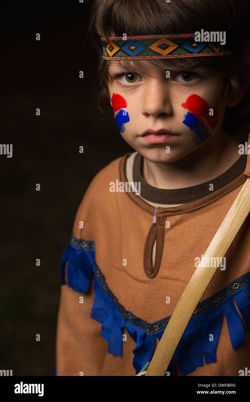 A young boy is dressed as an Indian on a black background Stock Photo