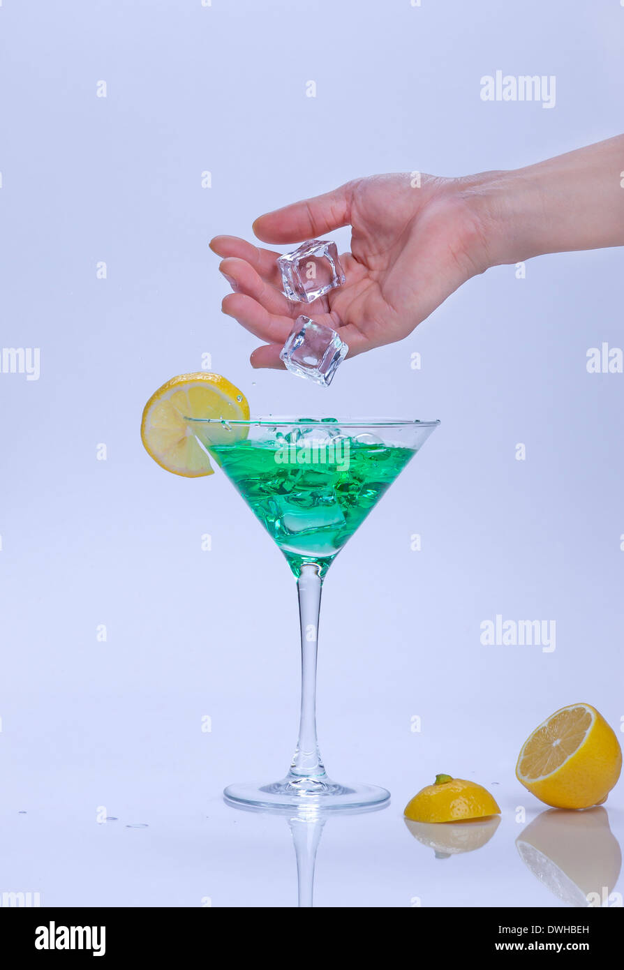 Dropping ice into cocktail. Stock Photo