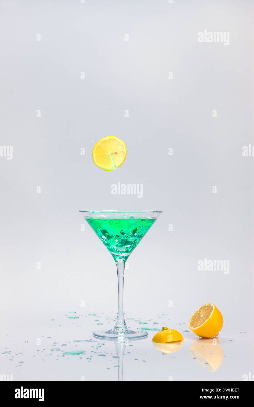 Dropping a lemon slice into a cocktail glass. Stock Photo