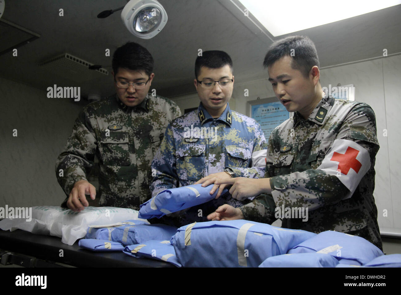 Zhanjiang. 9th March 2014. Members of a medical contingent check medical supplies on board of Chinese navy warship 'Jinggangshan' at Zhanjiang Port of south China's Guangdong Province, March 8, 2014. Upon the approval of the Central Military Commission, the amphibious landing ship 'Jinggangshan', loaded with life-saving equipments, underwater detection facilities and supplies of oil, water and food, set out from Zhanjiang port at about 3:00 a.m. on Sunday for search and rescue mission to sea area where missing Malaysia Airline flight MH 370 may have crashed. Stock Photo