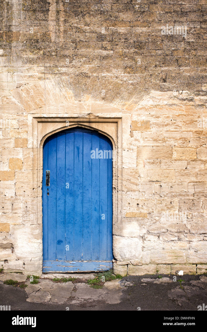 Old arched blue wooden door in Burford, Cotswolds, Oxfordshire, England