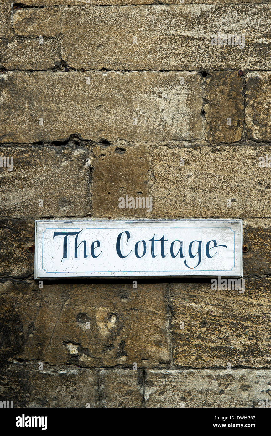 The Cottage sign on a cotswold stone wall. Cotswolds, England Stock Photo