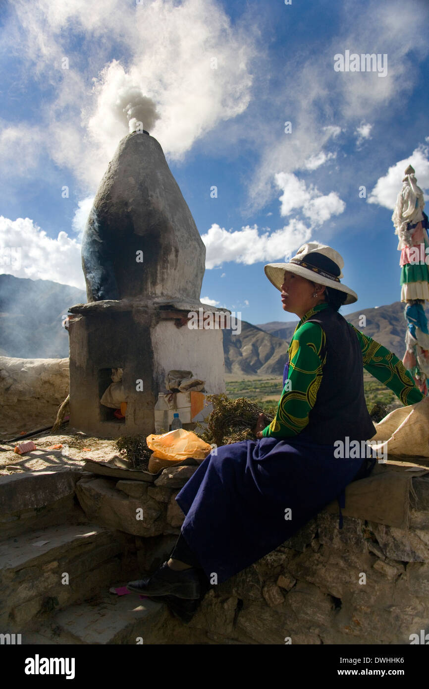 A Buddhist pilgrim burning aromatic plants to make a smoke prayer