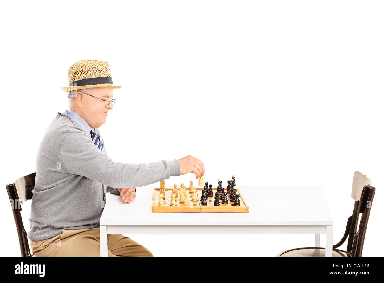 Senile old man playing a game of chess alone Stock Photo