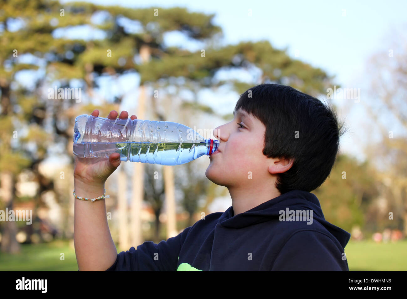A boy thirsty eagerly drinking water from plastic bottle Stock Photo