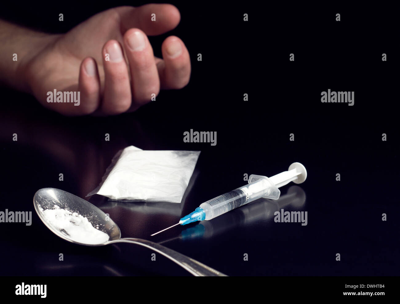 human hand and cooked heroin with syringe Stock Photo