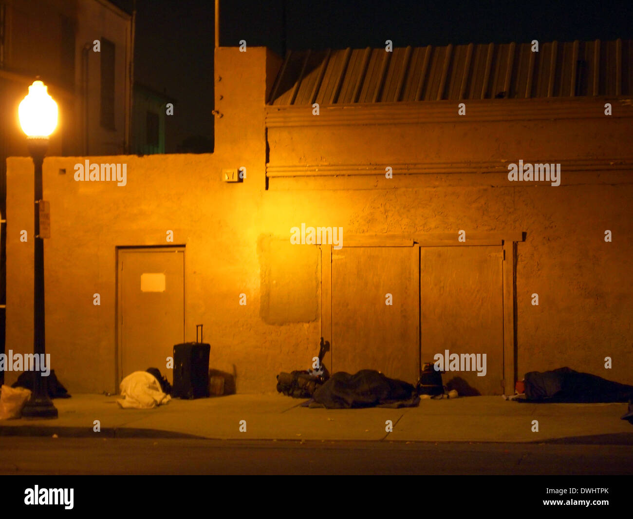 Homeless sleeping under the light of a street light in San Diego