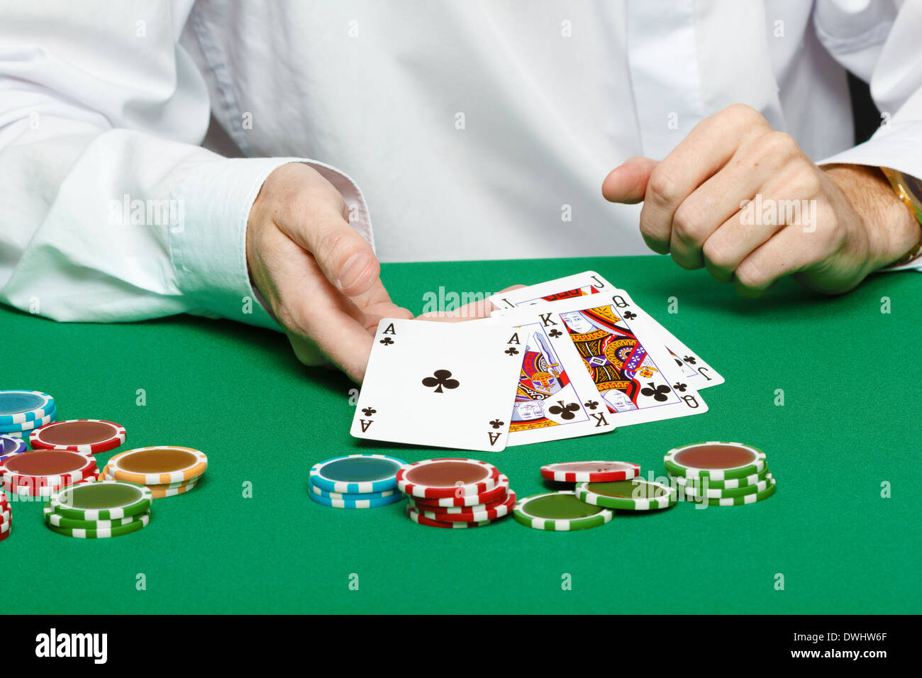 gambler. Male hand with cards and chips on green table Stock Photo