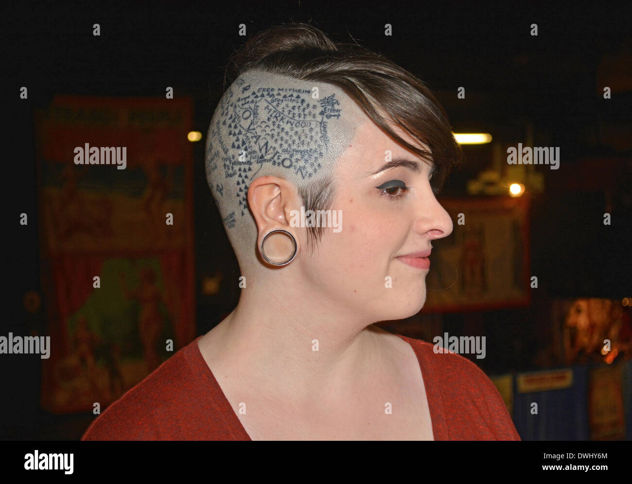 Portrait of a woman with a partially shaved head and tattoos of Middle Earth from Tolkien's Lord of the Rings. At a tattoo convention in Manhattan, NY Stock Photo