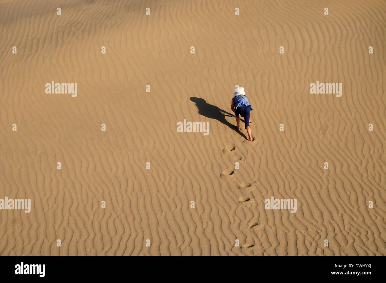 a girl climbing a dune in a desert Stock Photo - Alamy