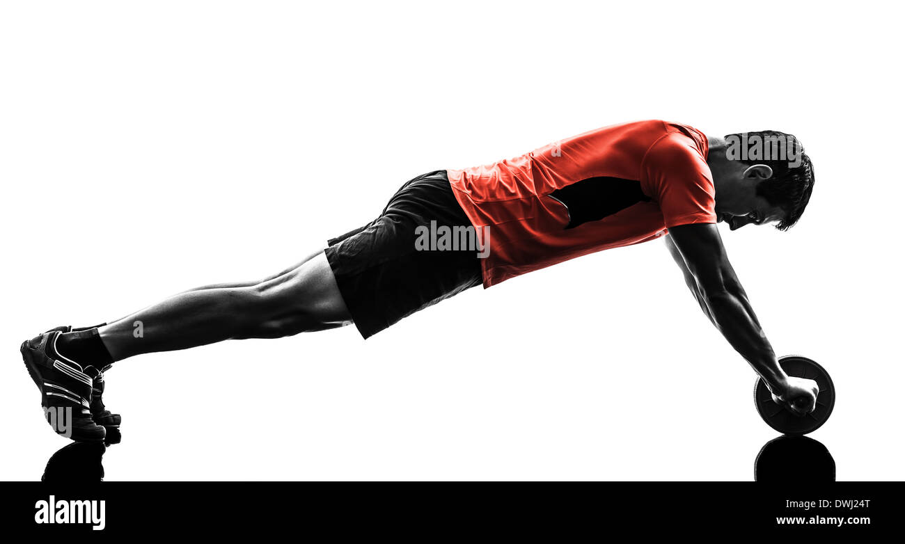 one man exercising fitness workout abdominal toning wheel in silhouette on white background Stock Photo