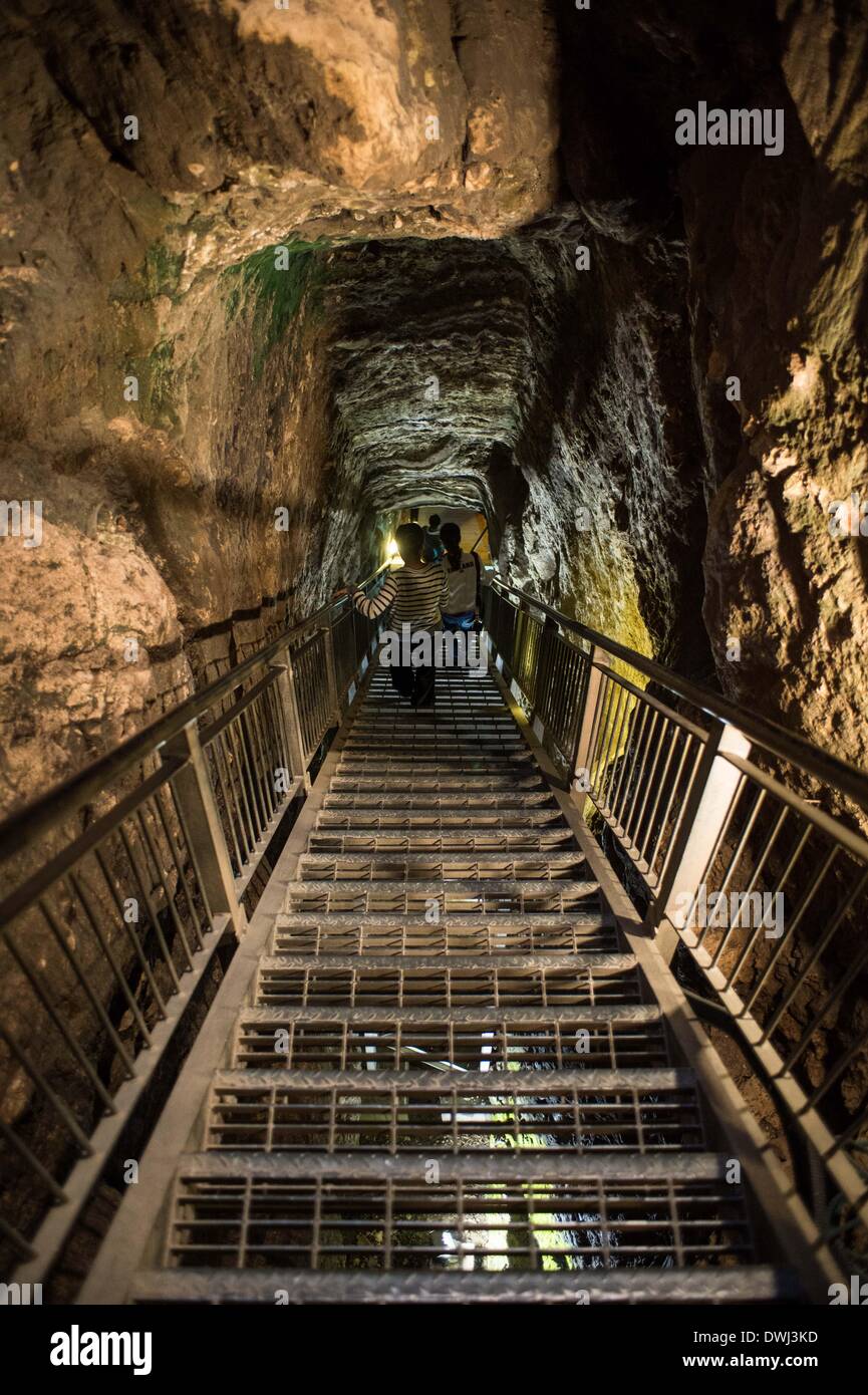 (140310) -- MEGIDDO (ISRAEL), March 10, 2014 (Xinhua) -- Visitors walk into remains of a huge water system in Megiddo National Park, Israel, March 8, 2014. The water system was hewn during the period of the Israelite kings, in order to bring water into the city without having to exit the walls. To this end, Megiddo's inhabitants dug a gigantic, 36-meter-deep shaft, from which a 70-meter-long horizontal tunnel extended to the spring, which emerged in a cave at the foot of the mound outside the walls. The Biblical Tels - Megiddo, Hazor, Beer Sheba in Israel were inscribed on the UNESCO World Her Stock Photo