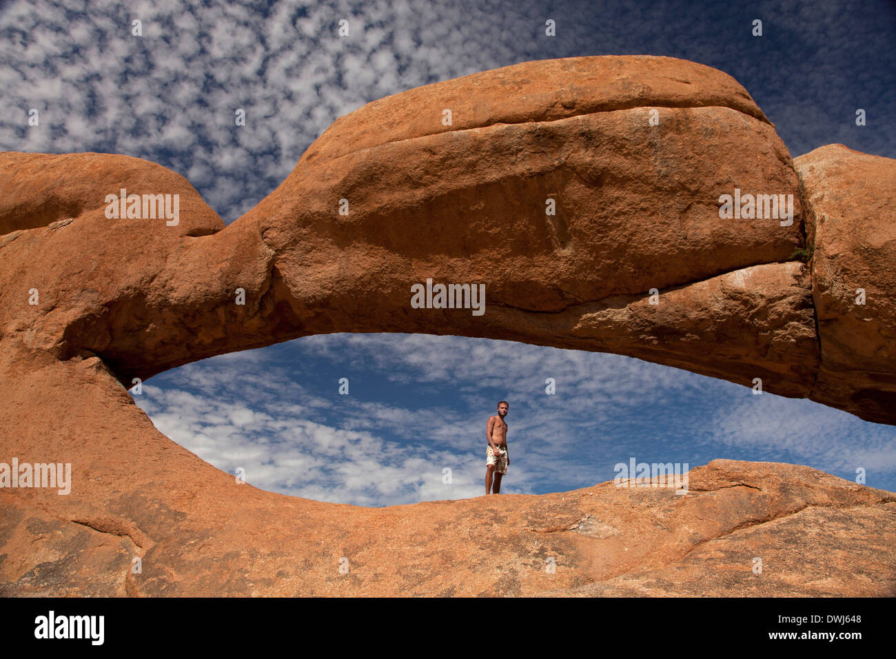 tourist at the rock arch near the granite mountain Spitzkoppe, Namibia, Africa Stock Photo