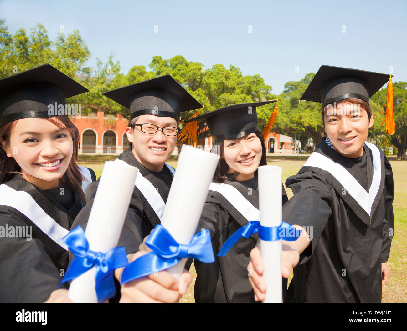happy college graduate show diplomas at ceremony Stock Photo