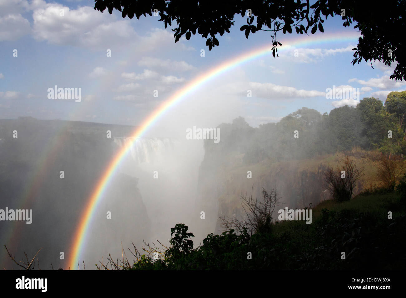 Rainbows in the spray at Victoria Falls on the Zimbabwe and Zambia border. Stock Photo