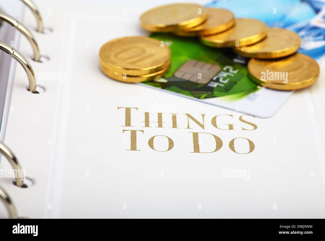 Credit card, golden coins on the page of an organizer with the words ''Things to do''. Selective focus Stock Photo