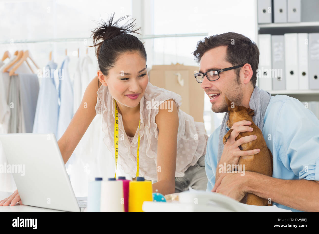 Fashion designers using laptop in studio Stock Photo