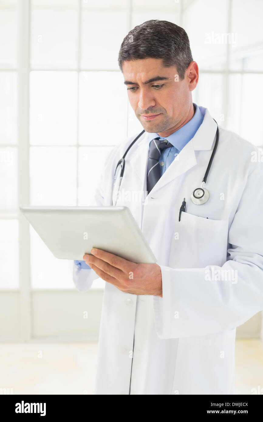 Serious male doctor using digital tablet Stock Photo