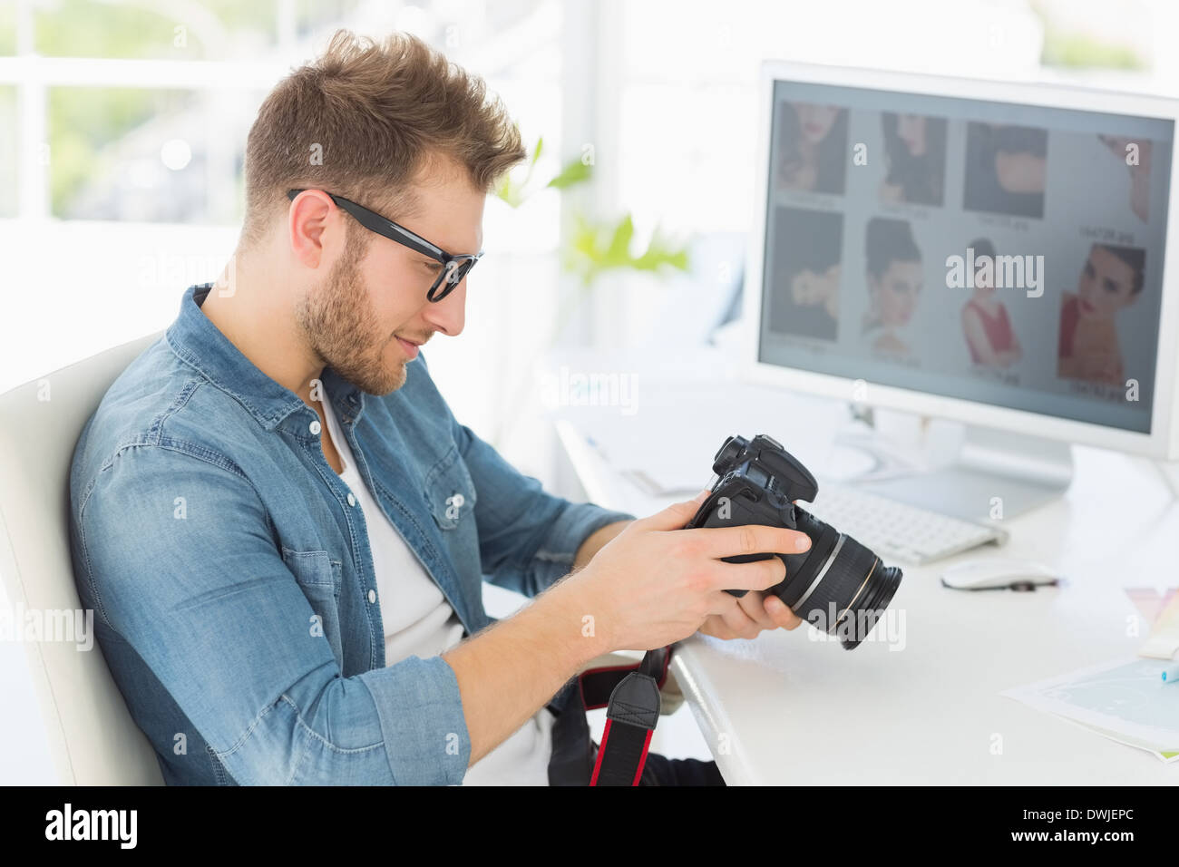 Handsome photographer looking at his camera Stock Photo