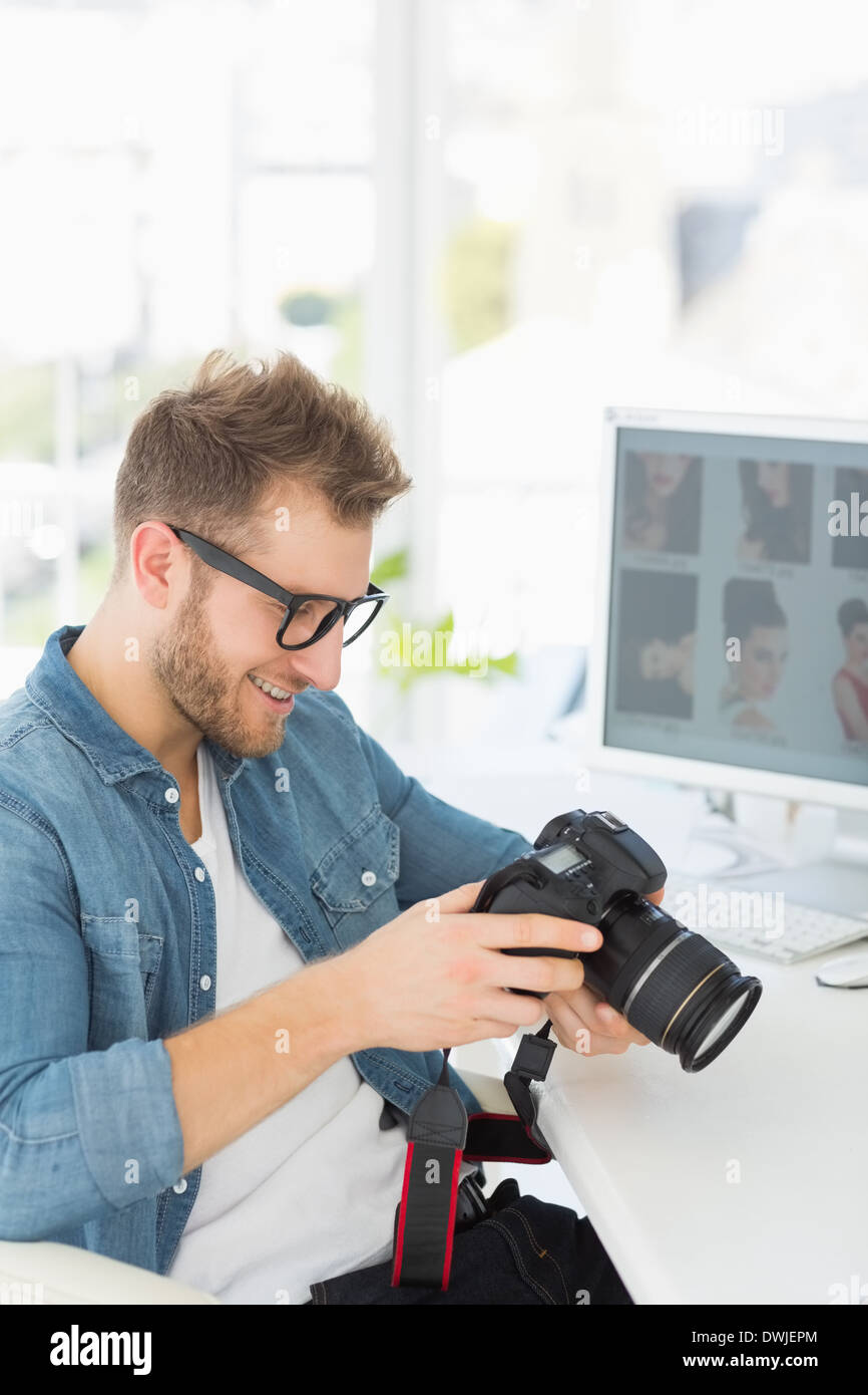 Handsome photographer holding his camera and smiling Stock Photo