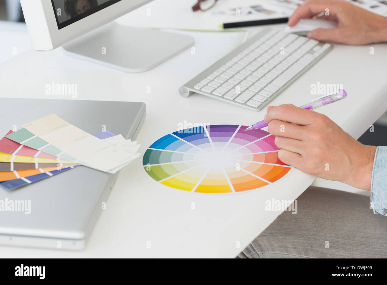 Designer working at her desk using a colour wheel Stock Photo