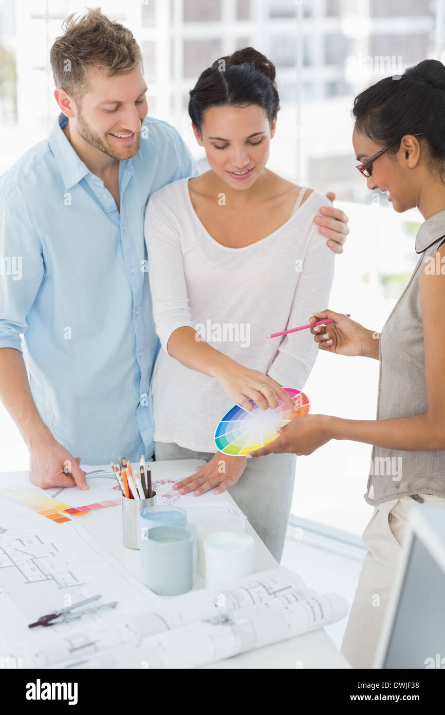 Interior designer showing colour wheel to smiling clients Stock Photo