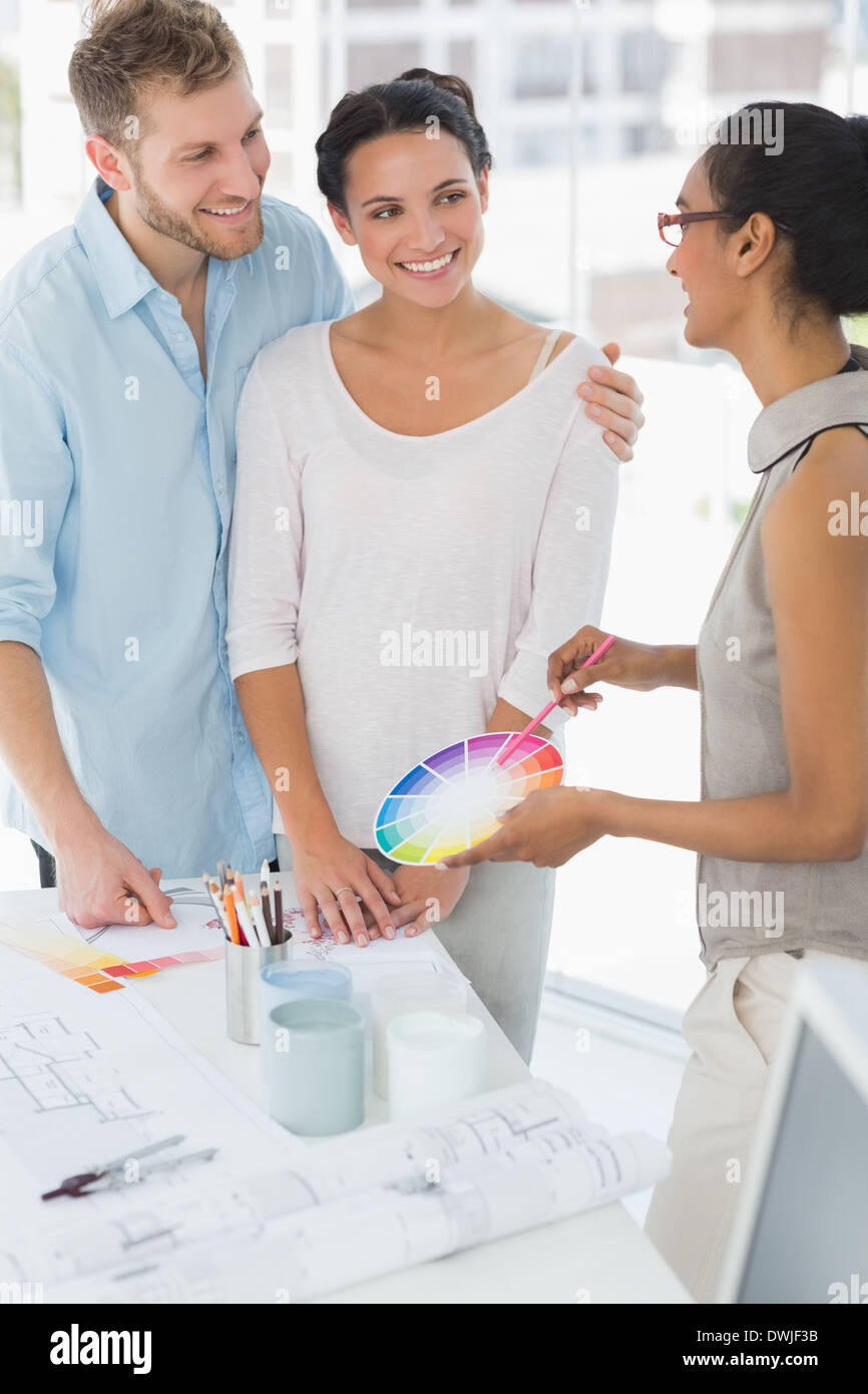 Interior designer showing colour wheel to happy clients Stock Photo