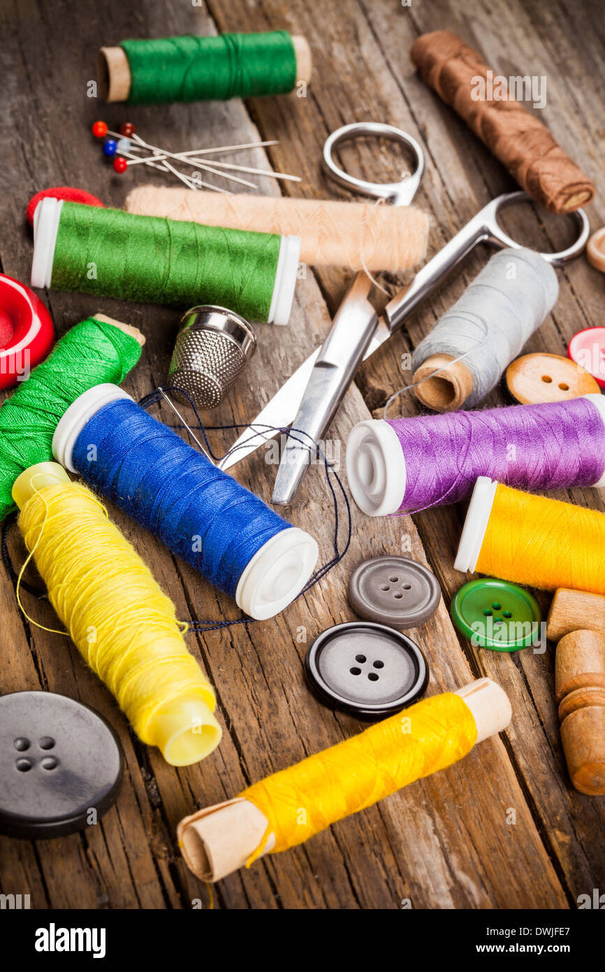 Scattered sewing spools and buttons, scissors and needles Stock Photo